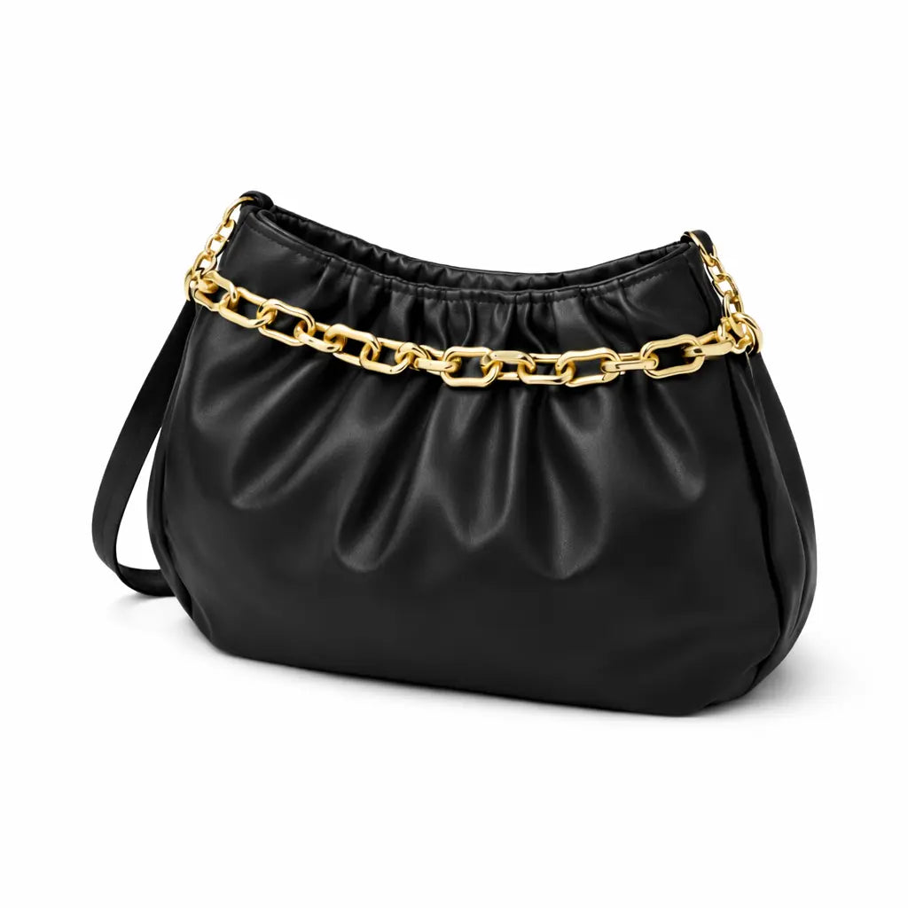 Black leather handbag with gold chain strap, modern purse on white background