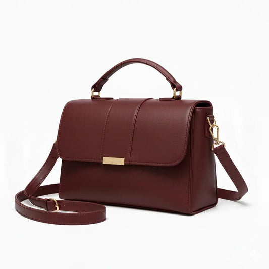 Burgundy leather handbag with gold hardware, top handle, and detachable shoulder strap