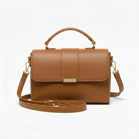 Brown leather handbag with top handle and adjustable shoulder strap on white background