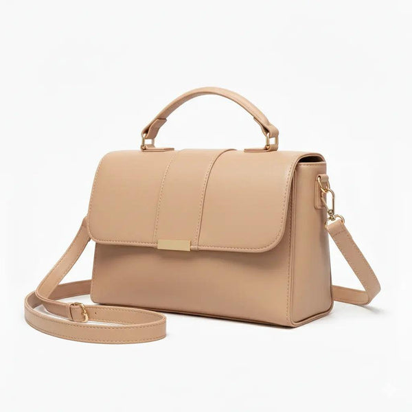 Beige leather handbag with top handle and gold hardware on white background