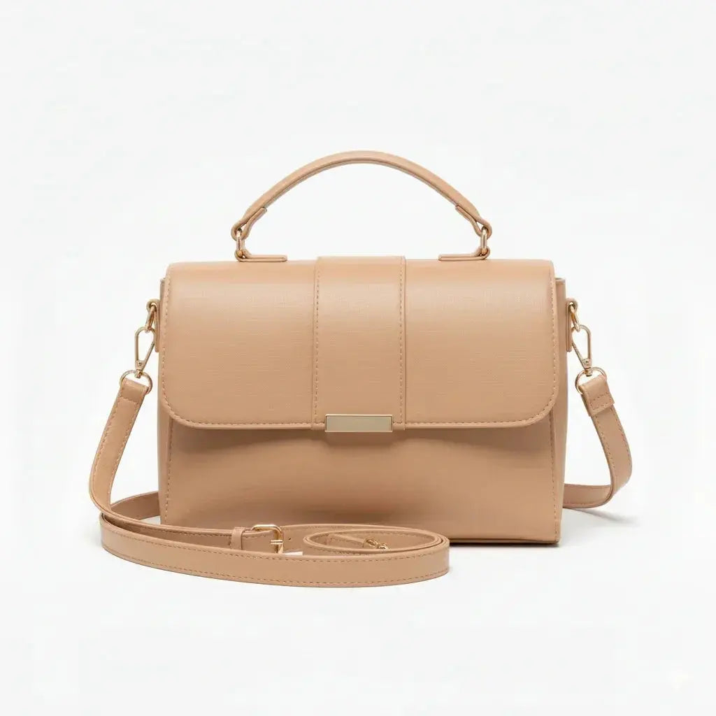 Beige leather crossbody handbag with top handle and gold hardware on white background